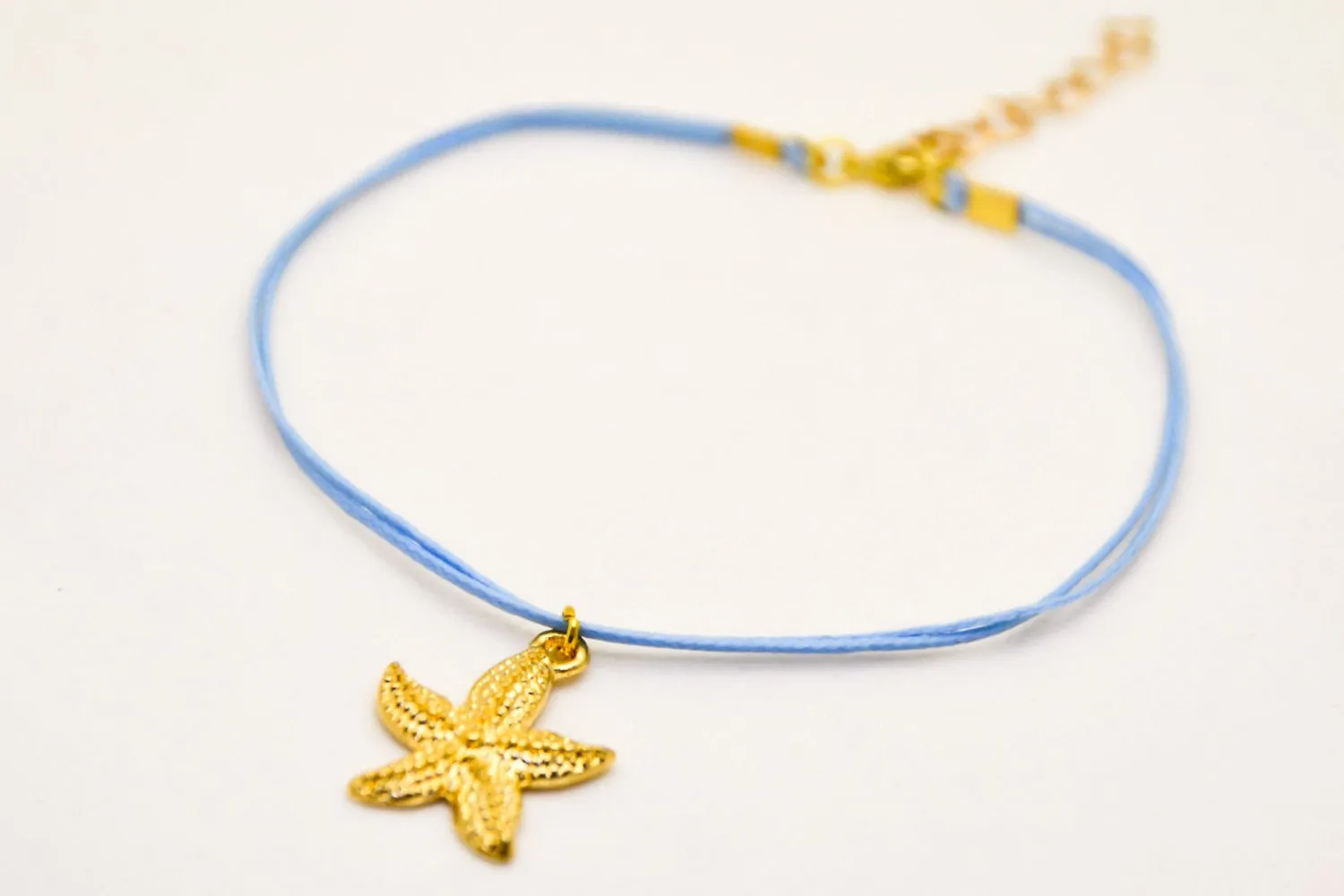 Ankle bracelet with a gold plated starfish dangle charm, blue cord, preppy jewelry